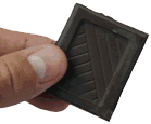 picture of hand holding a piece of dark chocolate
