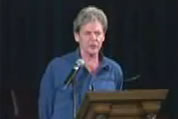 image of john mcmurtry at lectern; click to go to audio page; opens in new window