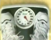 funny diet videos link; thumb of feet in athletic shoes on a scale