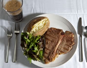 steak, potato, and salad on a plate, plus a soda; click to go to multimedia page at external site; opens in new window