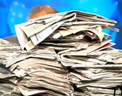 funny video about the death of newspapers link; thumb of man behind large stack of newspapers