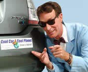 Bill Nye the Science Guy wearing sunglasses, pointing to a bumpersticker on a car that says 'Cool Car, Cool Planet' -- drive a hybrid
