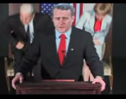 image of bush impersonator at lecturn; link for funny video; opens in new window